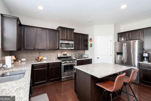 kitchen with backsplash, a center island, appliances with stainless steel finishes, dark hardwood / wood-style flooring, and sink