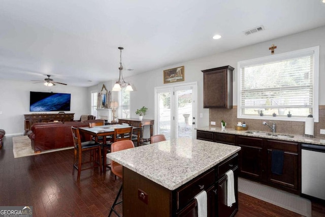 kitchen featuring sink, dark hardwood / wood-style floors, ceiling fan, a kitchen island, and stainless steel dishwasher