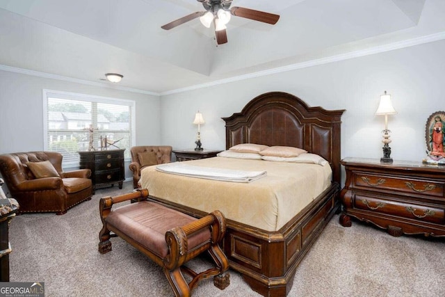 carpeted bedroom with a tray ceiling, ceiling fan, and ornamental molding