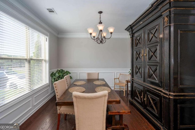 dining room featuring dark wood-type flooring, a notable chandelier, and ornamental molding