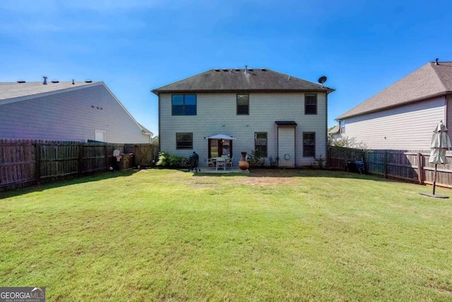 rear view of house with a lawn and a patio