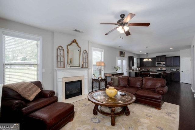 living room with plenty of natural light, hardwood / wood-style floors, and ceiling fan