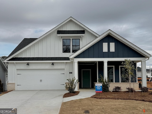 modern farmhouse with brick siding, board and batten siding, a shingled roof, a porch, and driveway