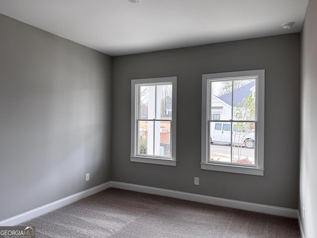 carpeted empty room with baseboards