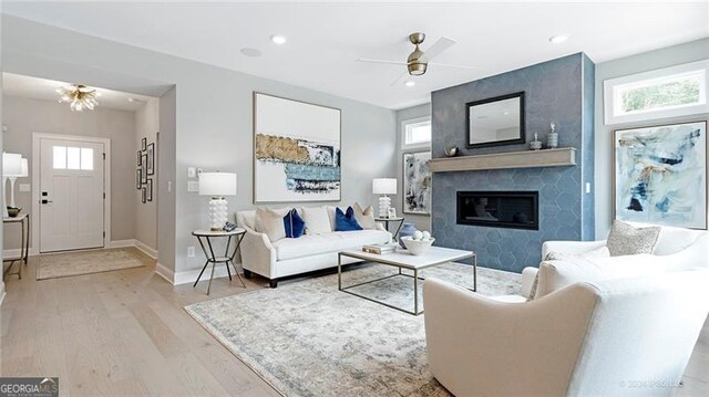 living room with a fireplace, light hardwood / wood-style floors, and a healthy amount of sunlight