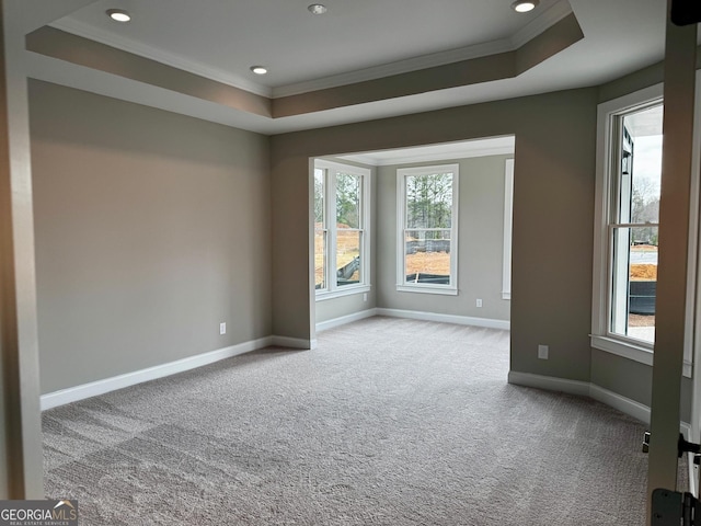 carpeted empty room featuring recessed lighting, crown molding, a raised ceiling, and baseboards