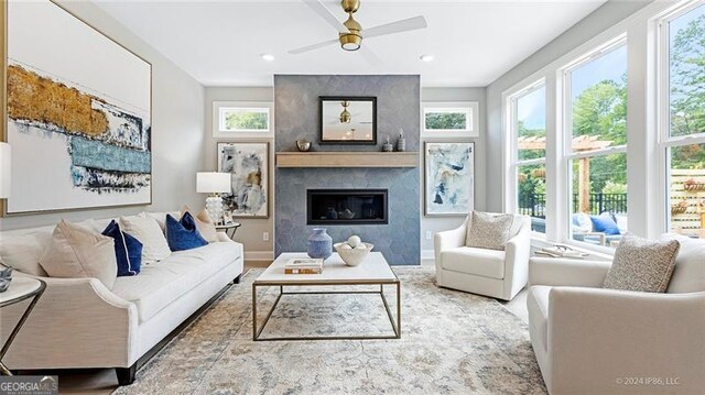 living room featuring ceiling fan and a high end fireplace