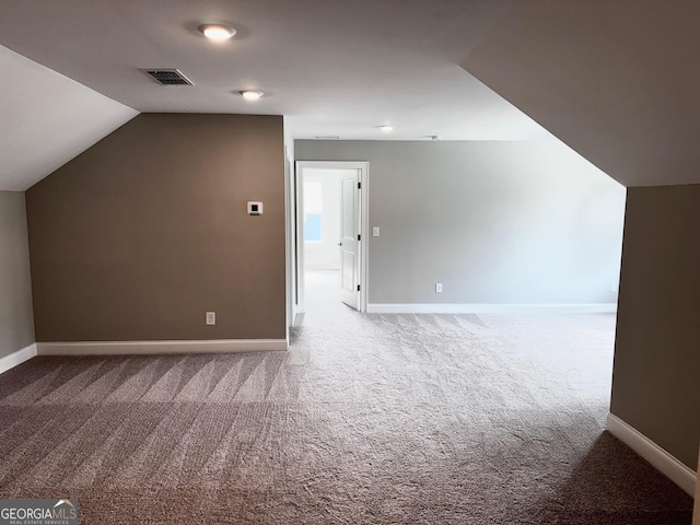 additional living space with baseboards, carpet, and vaulted ceiling