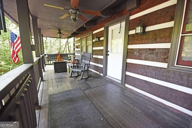 wooden terrace featuring a porch and ceiling fan