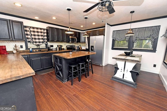 kitchen featuring a center island, a kitchen breakfast bar, dark hardwood / wood-style floors, and appliances with stainless steel finishes