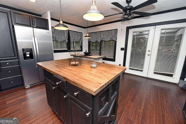 kitchen with stainless steel fridge, a kitchen island, decorative light fixtures, and dark hardwood / wood-style floors