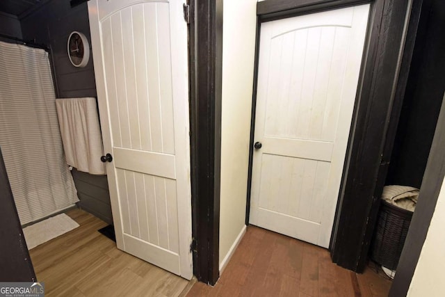 corridor with hardwood / wood-style flooring