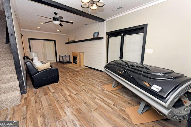 living room featuring light hardwood / wood-style floors, ceiling fan, a textured ceiling, and a fireplace