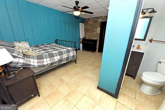 tiled bedroom with a paneled ceiling and ceiling fan