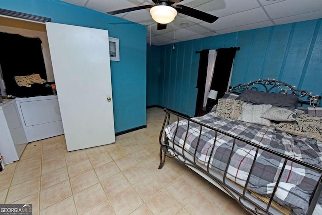 tiled bedroom with ceiling fan, a drop ceiling, and washer and clothes dryer