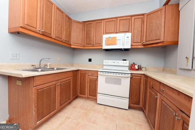 kitchen featuring white appliances, light tile patterned floors, and sink