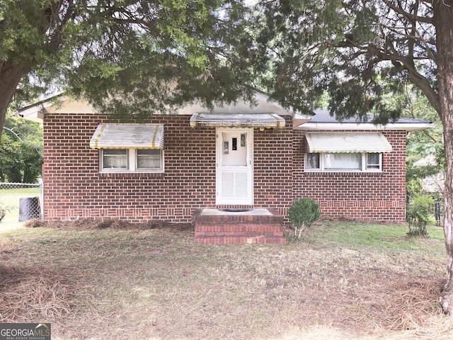 bungalow with brick siding and fence