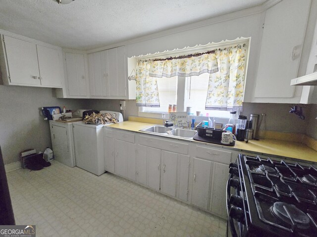 kitchen with white cabinetry, a textured ceiling, washing machine and clothes dryer, sink, and black range with gas stovetop