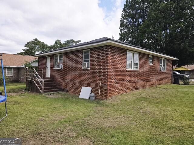 view of home's exterior featuring cooling unit and a yard