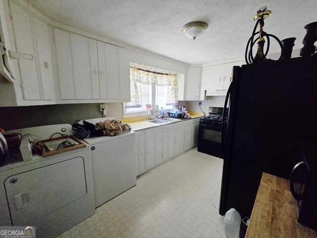 laundry room with separate washer and dryer, a textured ceiling, and sink