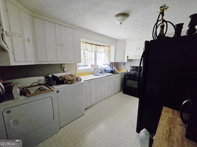 kitchen with black appliances, washer and dryer, a sink, light countertops, and light floors