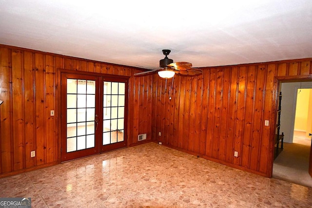 unfurnished room featuring wood walls, ceiling fan, and crown molding