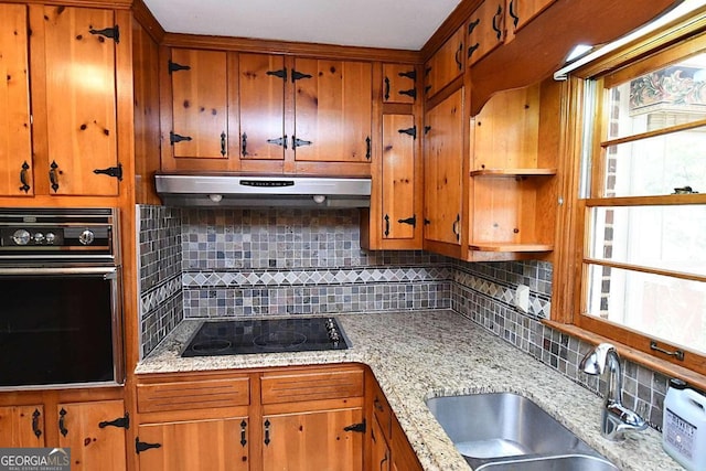 kitchen featuring black appliances, a healthy amount of sunlight, sink, and decorative backsplash