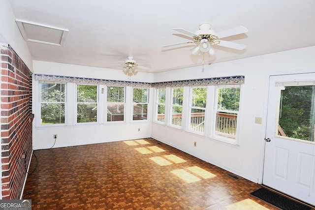 unfurnished sunroom featuring a healthy amount of sunlight and ceiling fan