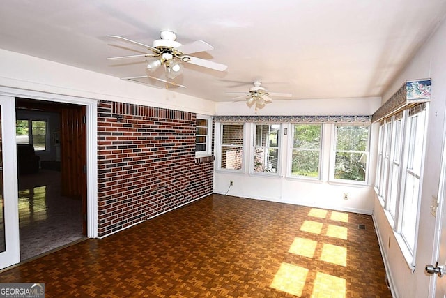 unfurnished sunroom featuring ceiling fan