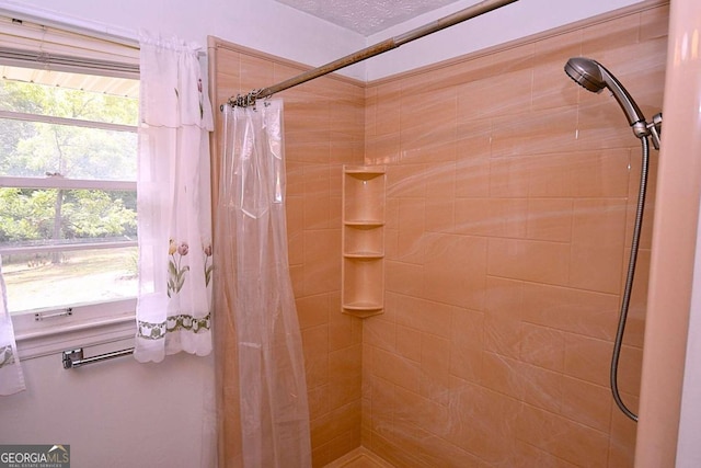 bathroom featuring curtained shower and a textured ceiling