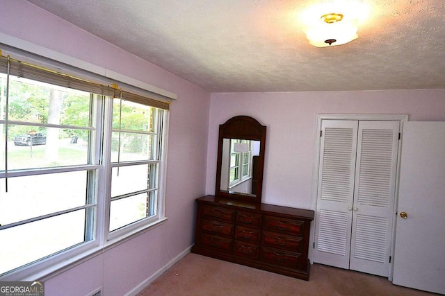 bedroom with a closet, carpet flooring, and a textured ceiling