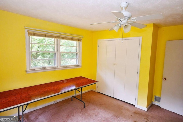 carpeted office featuring ceiling fan