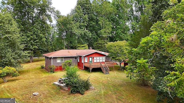 exterior space with a wooden deck and a lawn