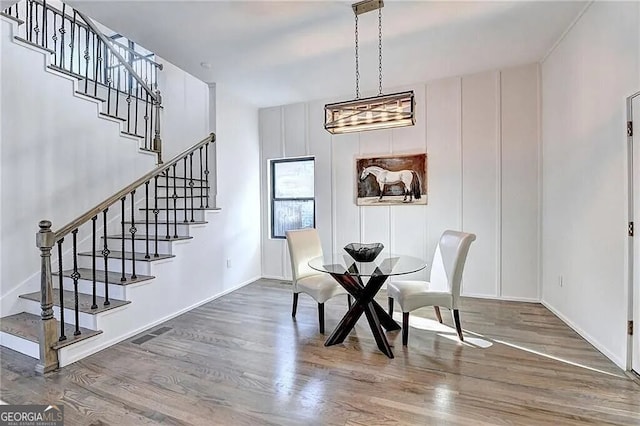 dining room with an inviting chandelier and wood-type flooring