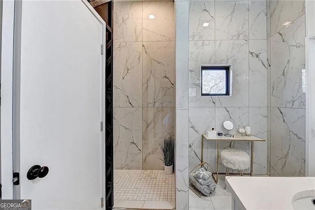 bathroom with a tile shower and vanity