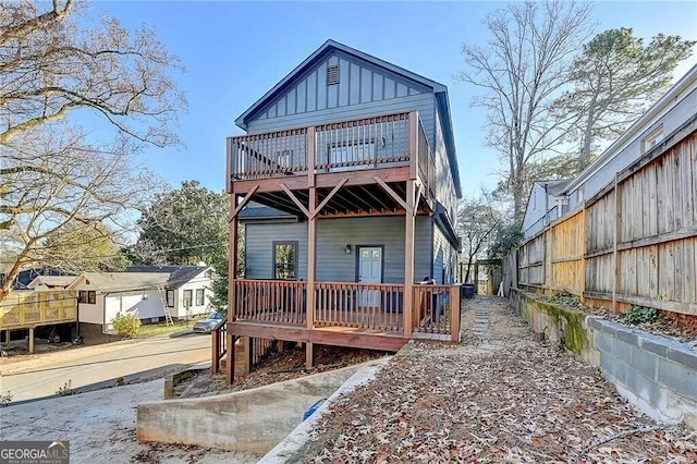 rear view of property featuring a wooden deck