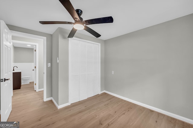 unfurnished bedroom with light hardwood / wood-style flooring, ceiling fan, and a closet