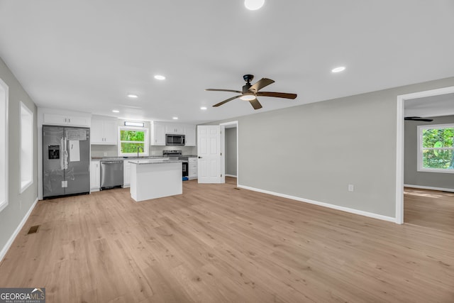 kitchen with light wood-type flooring, white cabinetry, sink, ceiling fan, and appliances with stainless steel finishes