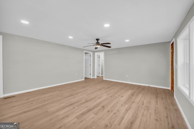 empty room with ceiling fan and light hardwood / wood-style floors