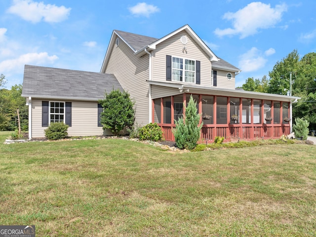 view of front of home with a front yard and a sunroom