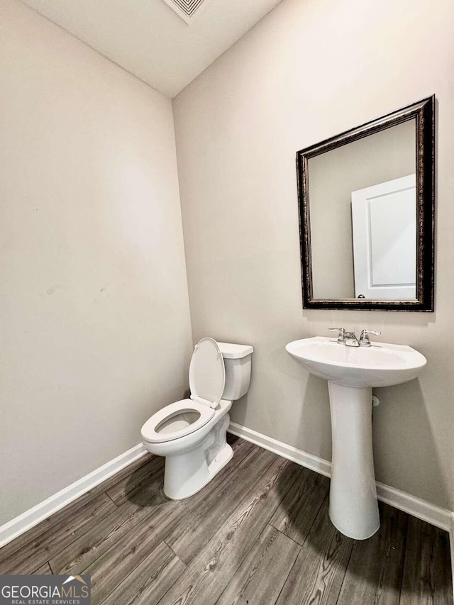 bathroom featuring hardwood / wood-style floors and toilet