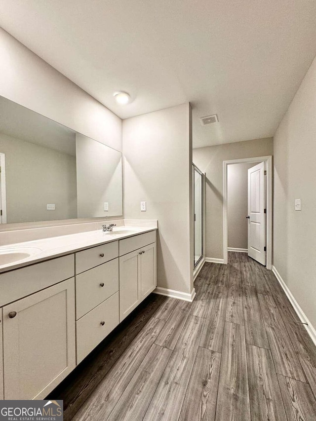 bathroom with hardwood / wood-style floors, an enclosed shower, a textured ceiling, and vanity