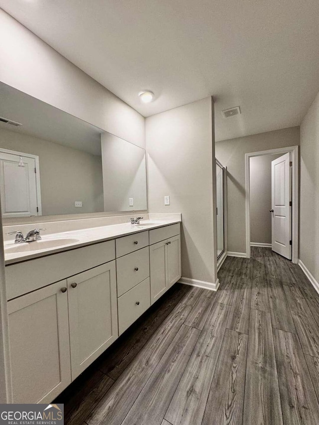 bathroom with vanity, an enclosed shower, and hardwood / wood-style flooring