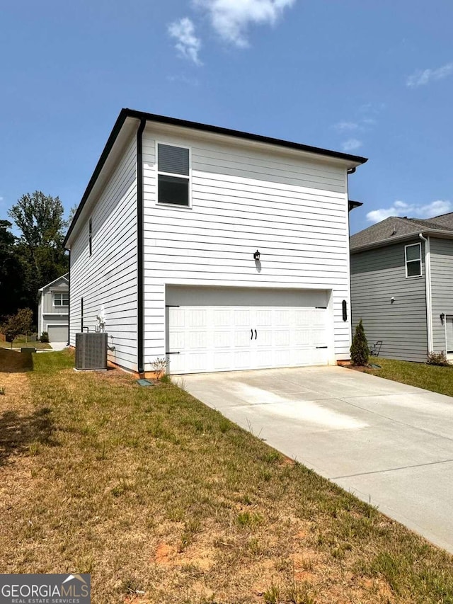 view of home's exterior featuring a yard, a garage, and central AC