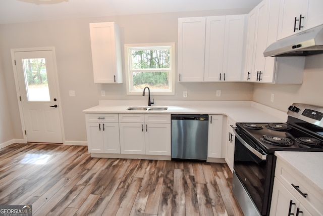 kitchen with stainless steel appliances, sink, light wood-type flooring, and white cabinets