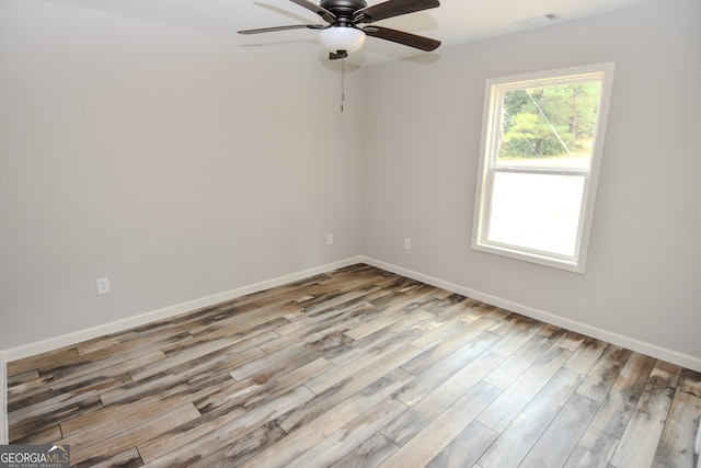 spare room with ceiling fan and light wood-type flooring