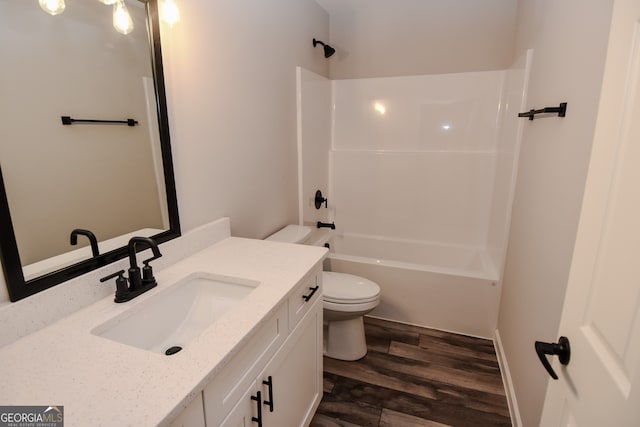 full bathroom featuring vanity, toilet, washtub / shower combination, and hardwood / wood-style flooring