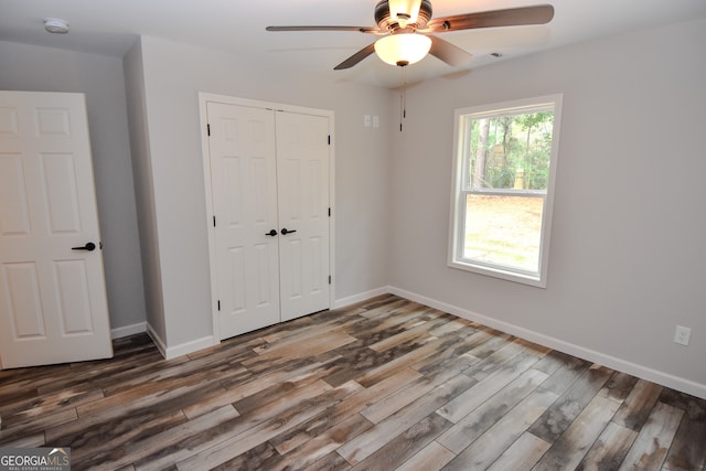 unfurnished bedroom featuring multiple windows, ceiling fan, and hardwood / wood-style flooring