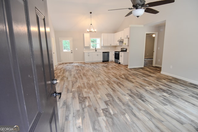 unfurnished living room featuring vaulted ceiling, sink, ceiling fan with notable chandelier, and light wood-type flooring