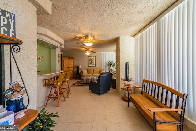 tiled living room with ceiling fan and a textured ceiling